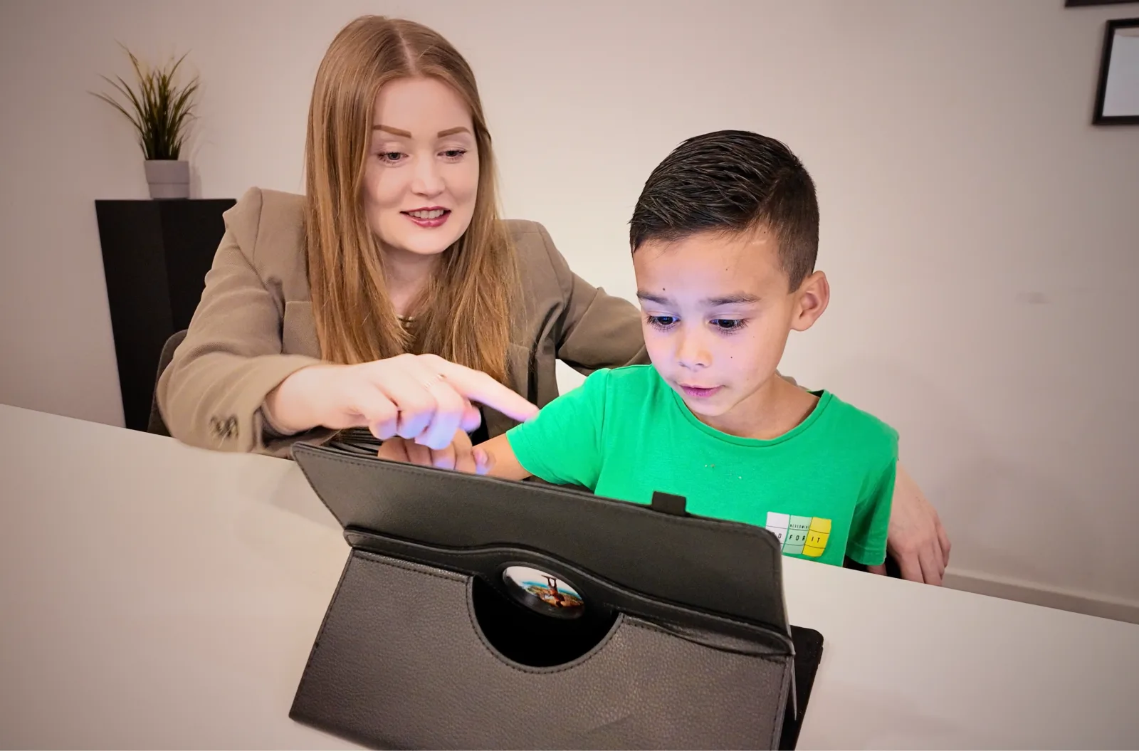 A teacher guiding a student through a WLearn activity on a tablet